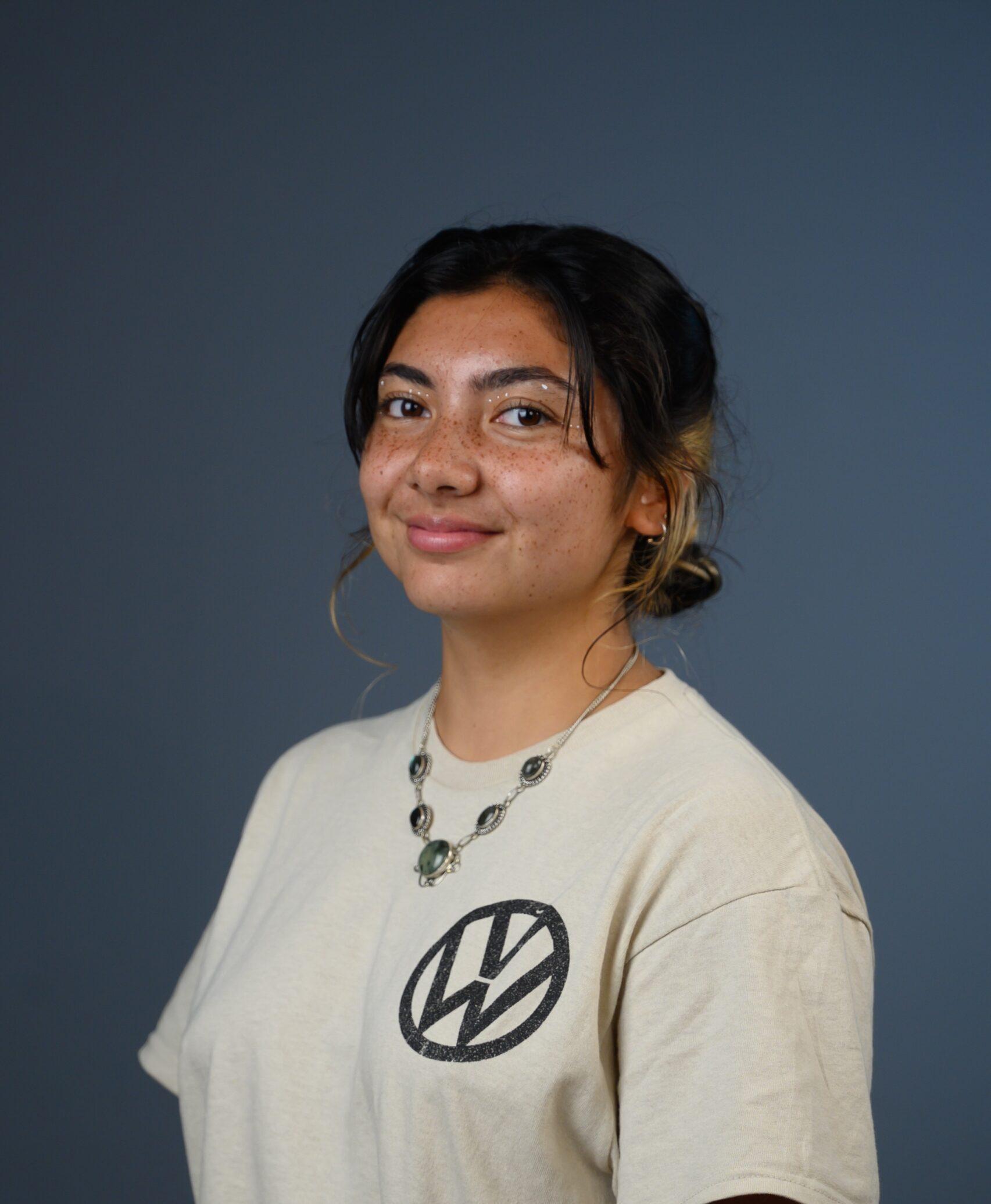 A female student is slightly angled toward the left as she smiles for the camera.