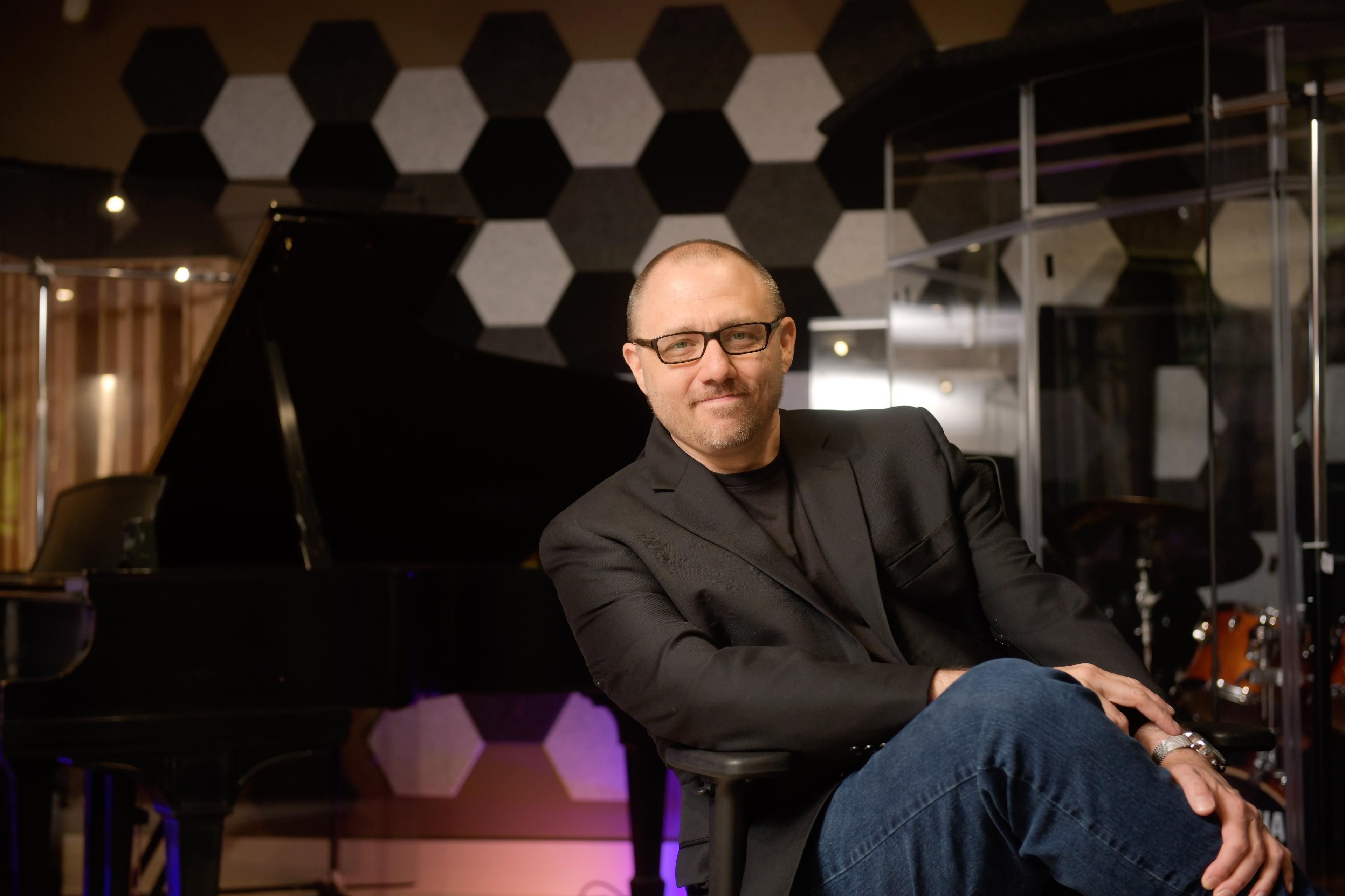 Dr. Douglas Drewek posing legs cross looking into the camera